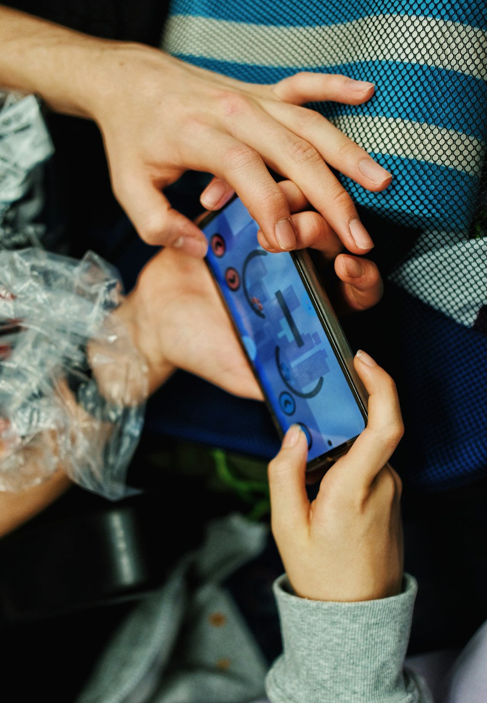 Dos personas juegan a un juego digital en un smartphone.